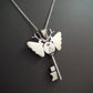 Silver andmoth key pendant necklace on a dark background. The piece deer antlers as antennas. Stamped BJ for designer Brydie Jayne and 925 for Sterling Silver 