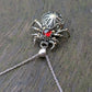 Sterling Silver and 9ct yellow Gold spider pendant featuring a gothic rose window inspired design and a garnet cabochon as the head.