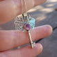 Silver moth key necklace with a purple gemstone held in hand