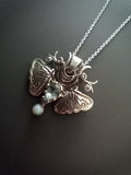 Sterling Silver Moth Pendant featuring Aquamarine, white opal and cubic zirconia. Detailed moth wings are made up of two months meeting at top where deer antlers are in place of antennas.