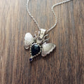 Sterling Silver Moth Pendant featuring Rose cut dark blue sapphire and iolite. Detailed moth wings are made up of two months meeting at top where deer antlers are in place of antennas.